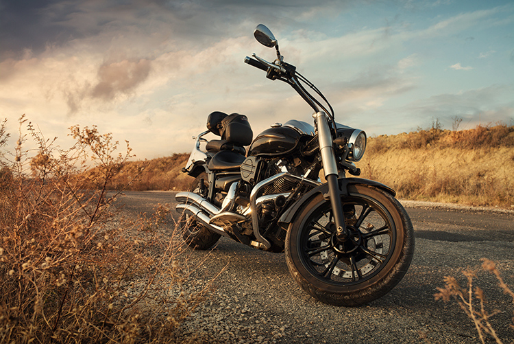 A black motorbike parked on rural road