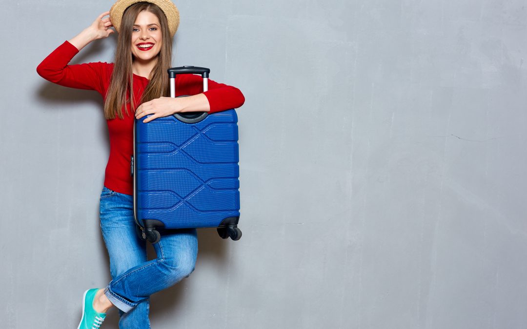 Woman holding a blue suitcase and smiling
