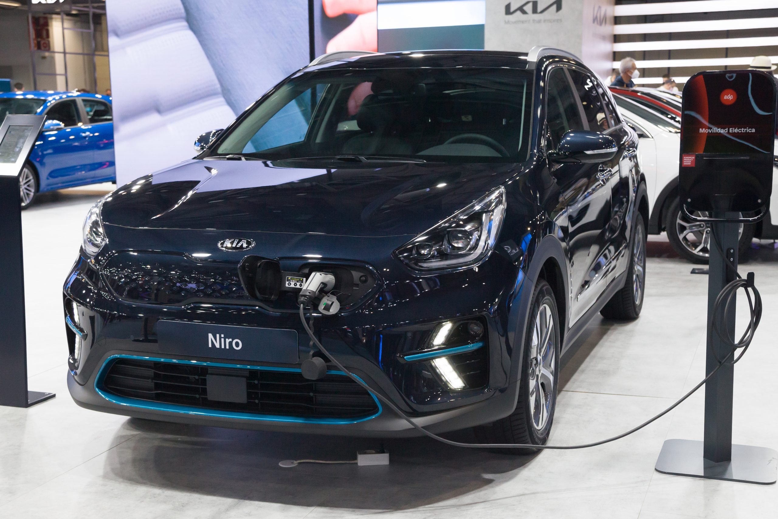 A navy Kia e-Niro parked charging in a show room