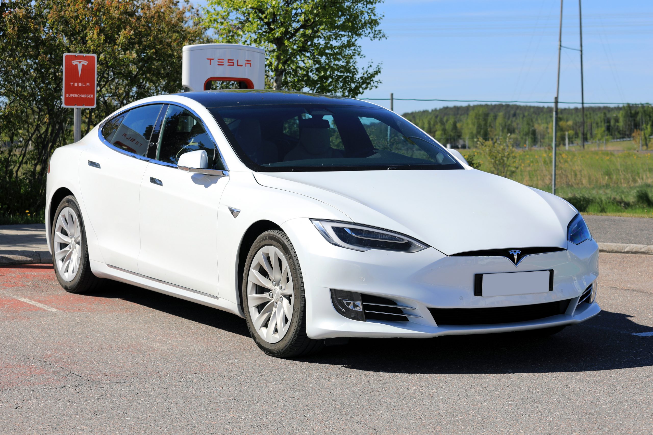 New white Tesla Model S  parked in front of Tesla Electric Car Supercharging