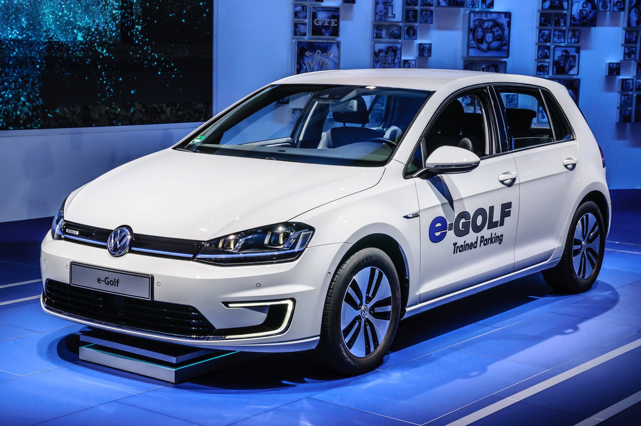 While Volkswagen e-Golf in a blue lighted showroom