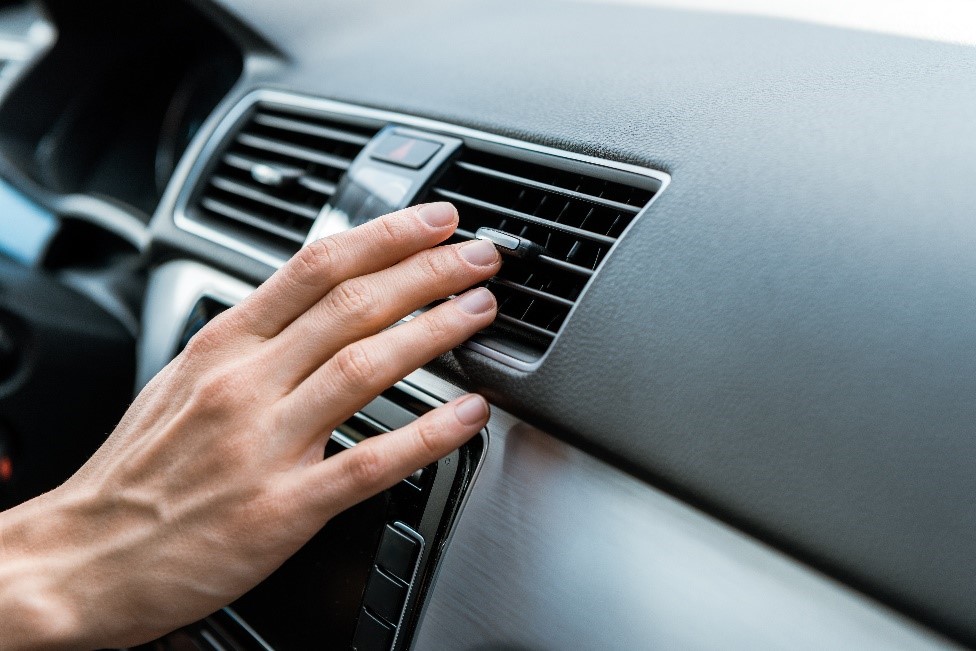 Someone adjusting their car air conditioning vents 