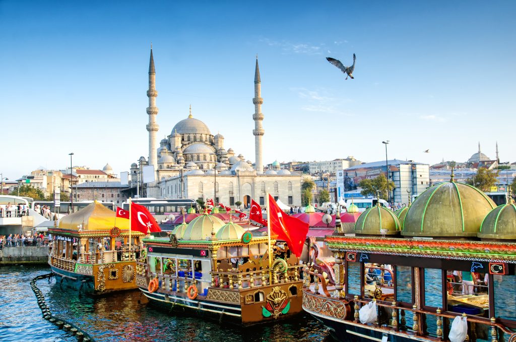 3 Colourful boats on  river in Istanbul, Turkey in front of the Blue Mosque