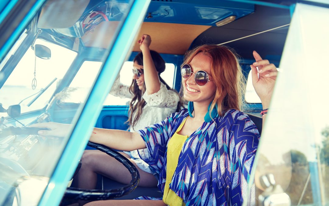smiling young women driving minivan
