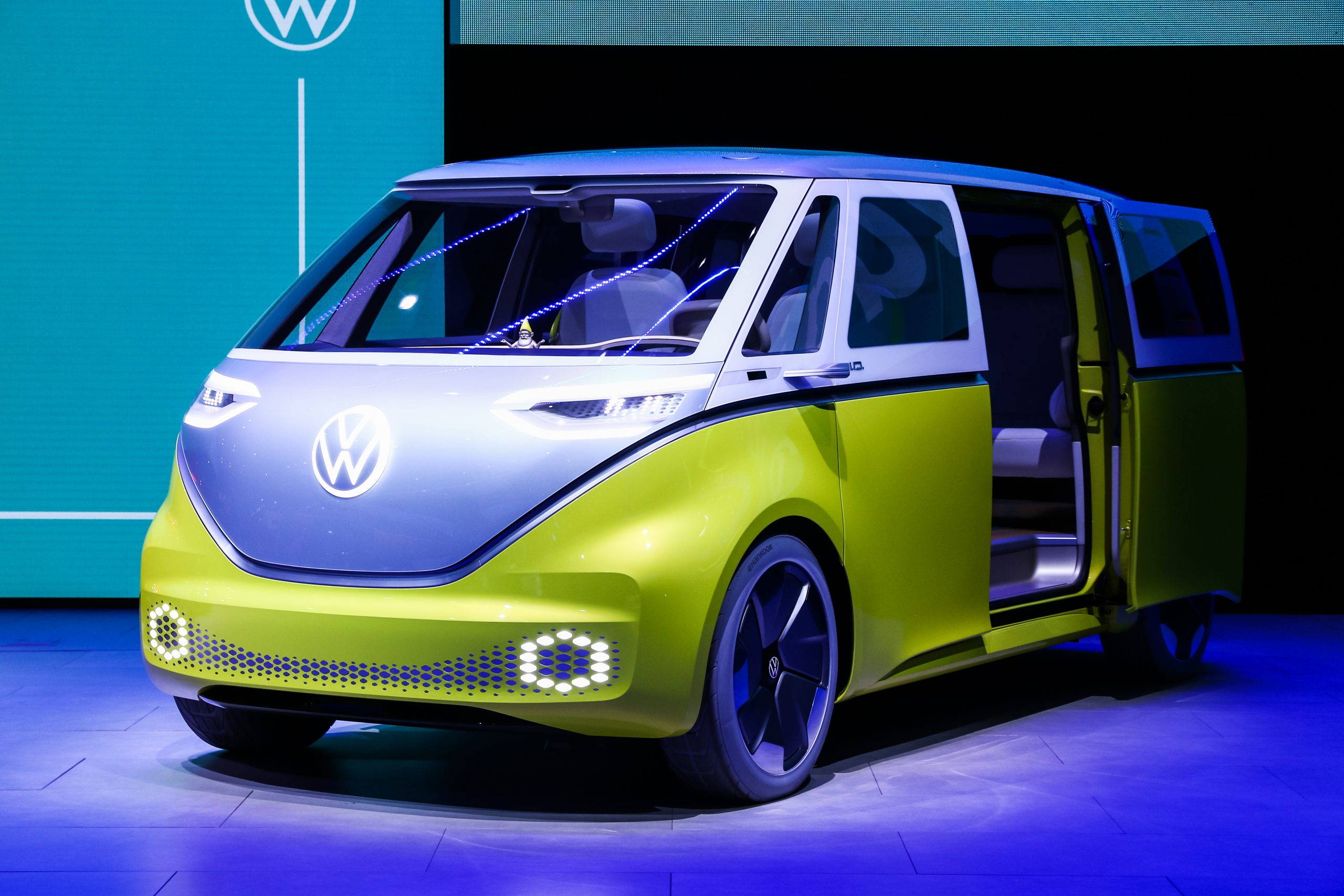 White and Lime green electric Volkswagen ID Buzz campervan. In a blue lit show room
