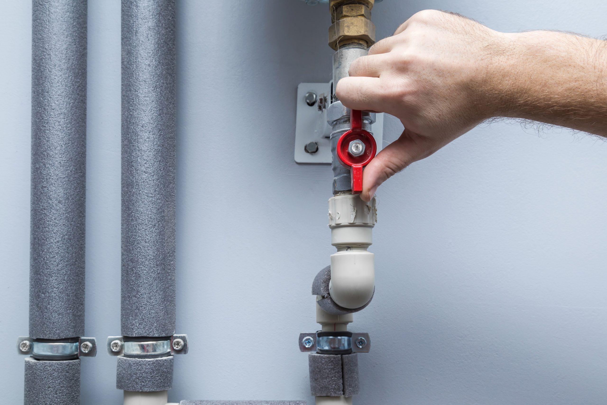 Man working at pipes. Turning on or turning off water supply in