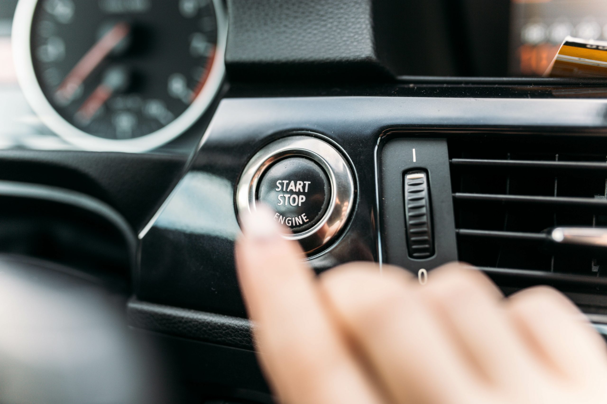 finger pressing the start button, stop the engine in the car. 