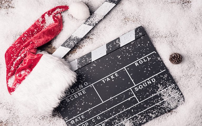 A fake snowy background with a black slack card with a red and white santa hat