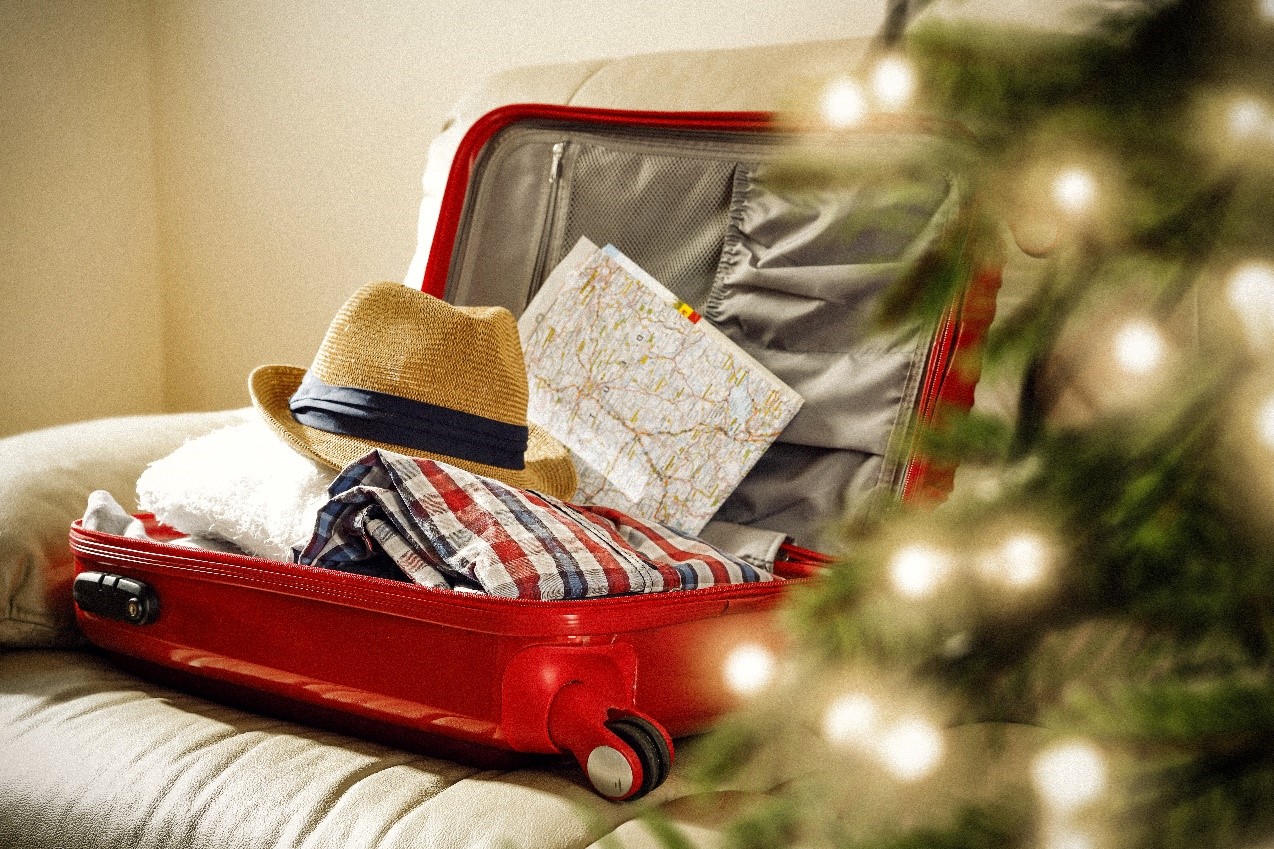 Suitcase next to a christmas tree