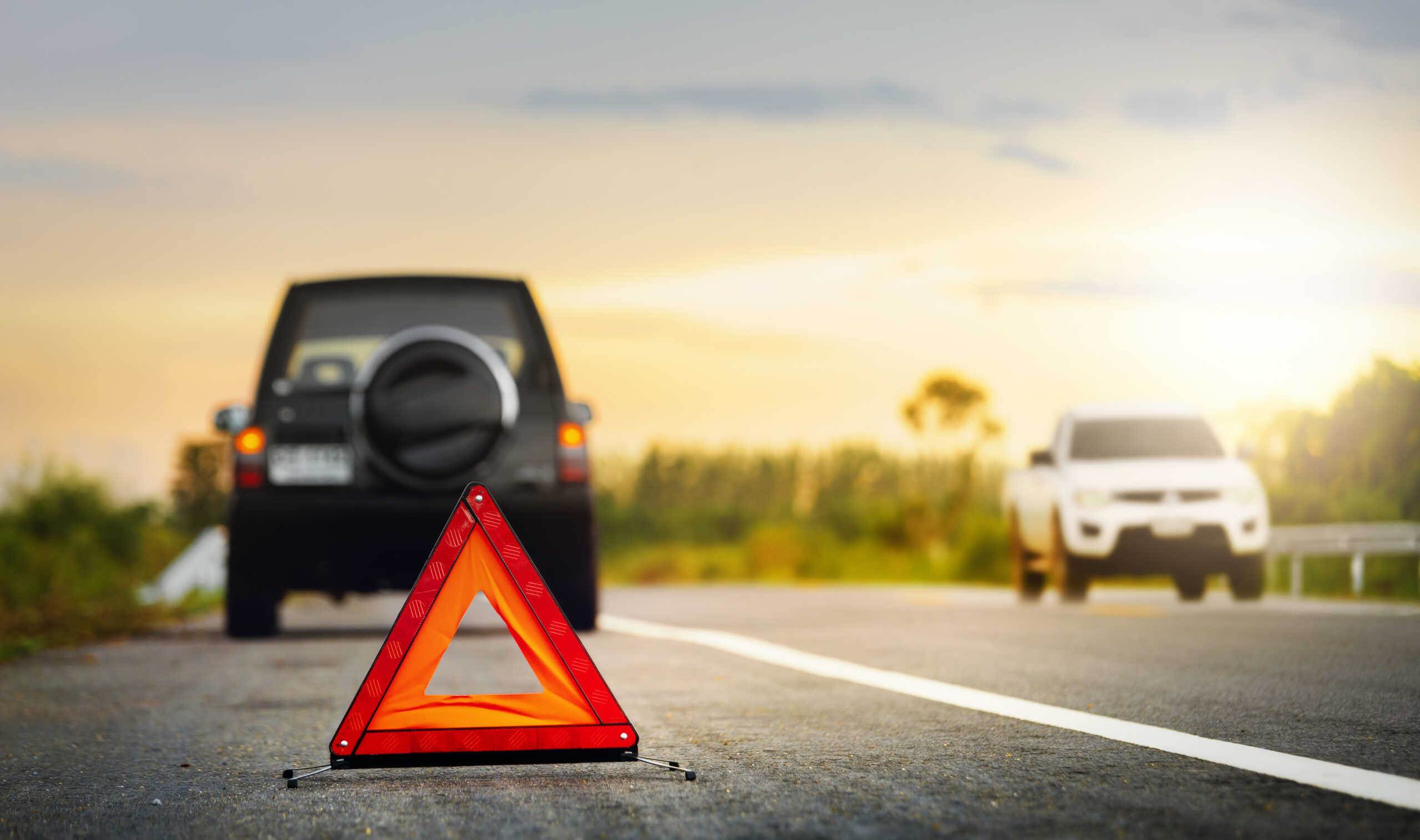 Red emergency stop sign (red triangle warning sign) and broken down vehicle