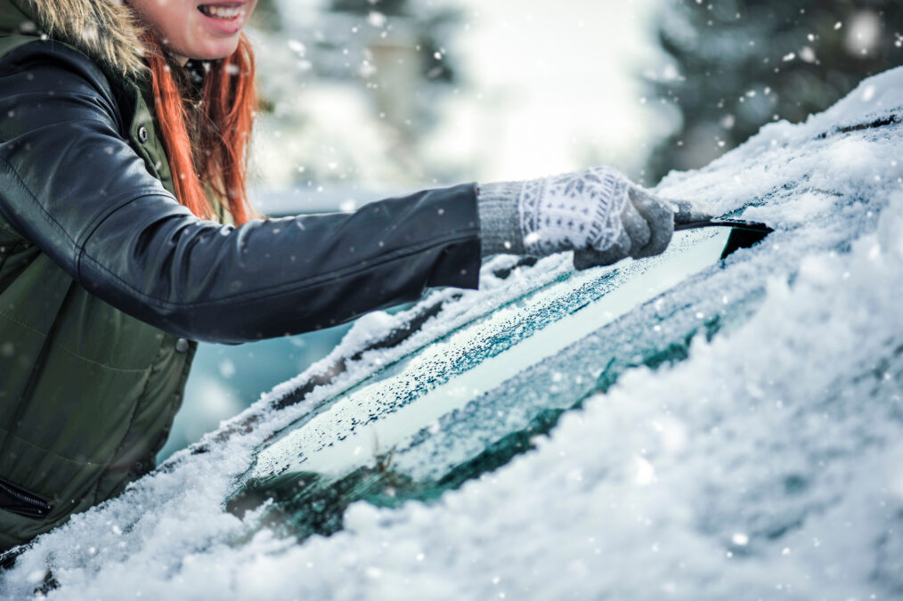 Removing snow from car windshield.  Clean car window in winter from snow.