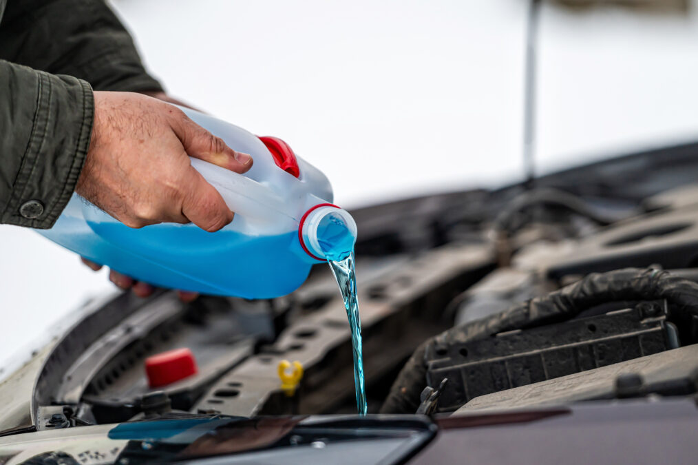 Man filling car with windscreen wash