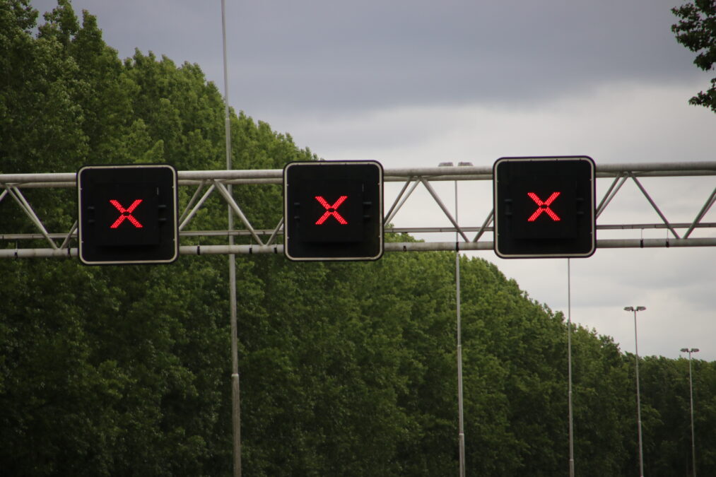 3 Electronic over head road signs displaying a red X. 