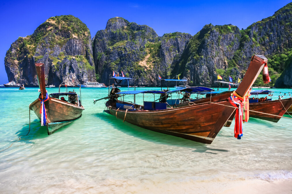 Long tail boat on white sand beach with crystal clear sea, Thailand