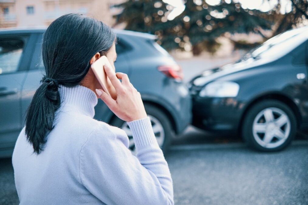 Woman on the phone at the scene of a car crash