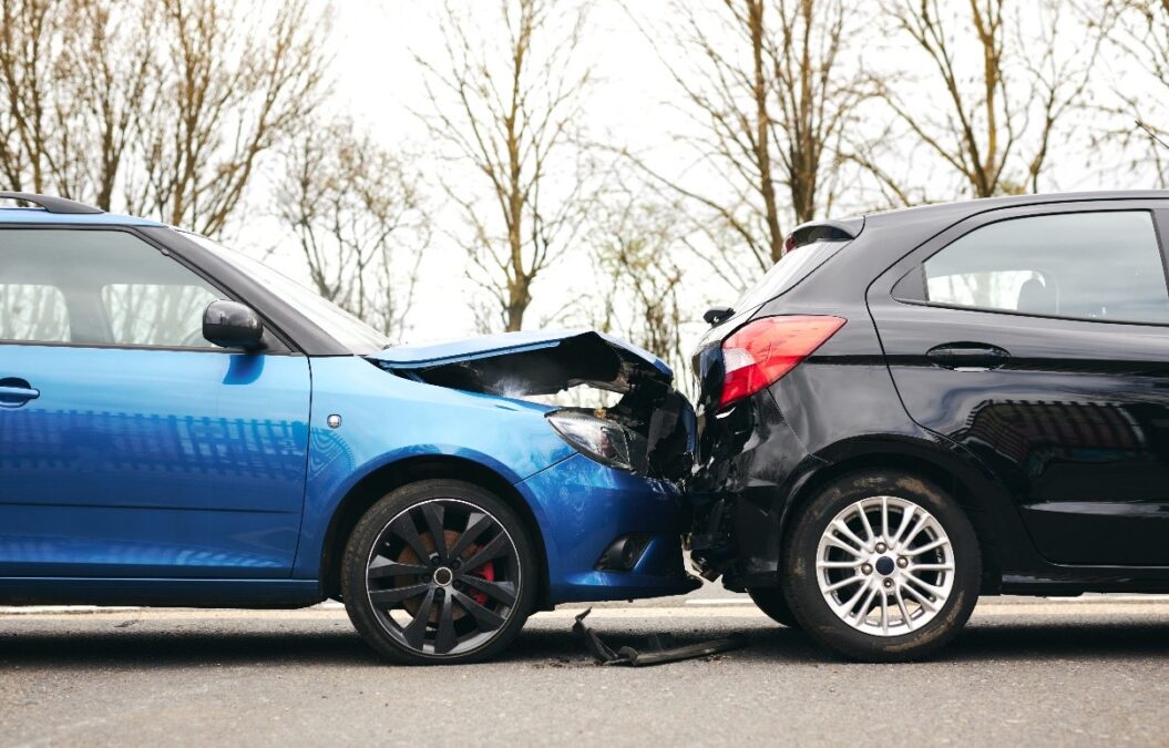 Blue car with its bonnet crushed in after rear ending a black car