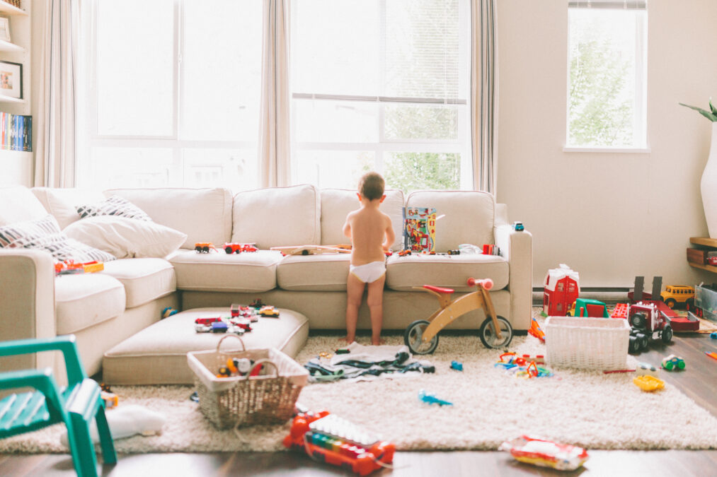 Child in room surrounded by toys everywhere