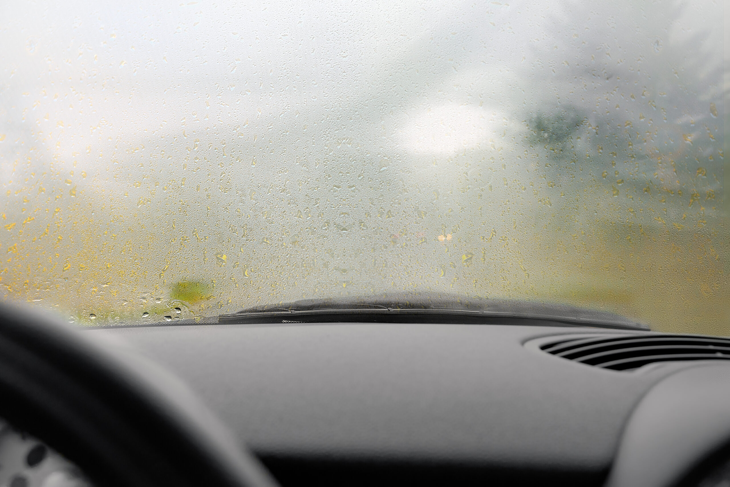 A point of view shot of the inside of a car dashboard. With a misted up windscreen.
