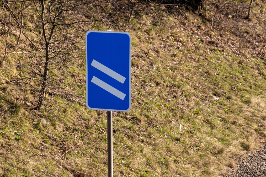 Blue road sign with two white dashes signaling 200 yards to sliproad