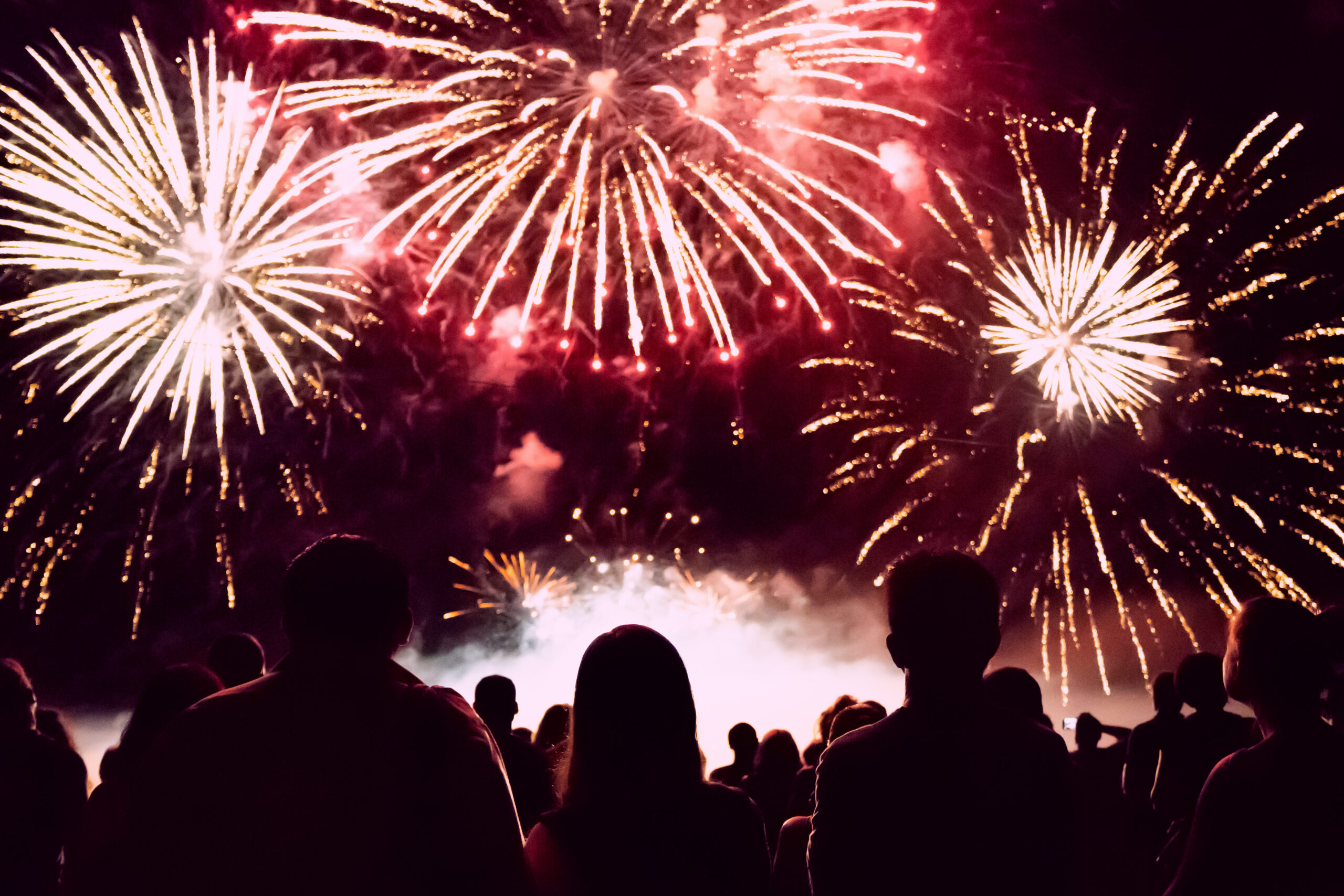 Silhouette of people watching a firework display 