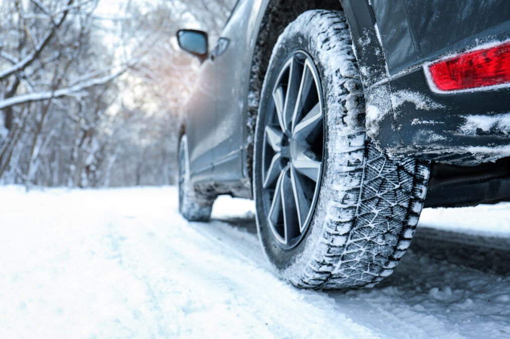 Snowy country road with car on winter day, closeup. 