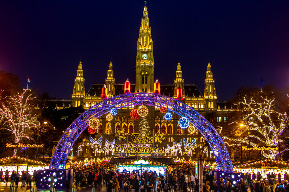 The Illuminating gate in front of the Christmas market by City hall -  Rathaus in night Vienna, Austria.