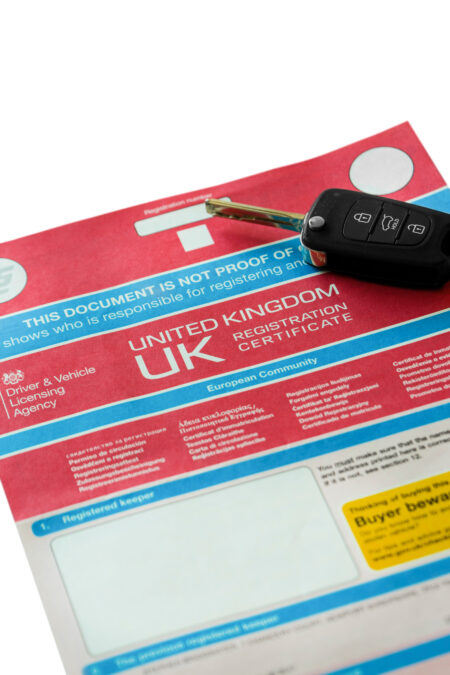 V5C car log book with electronic key fob. Isolated on a white background